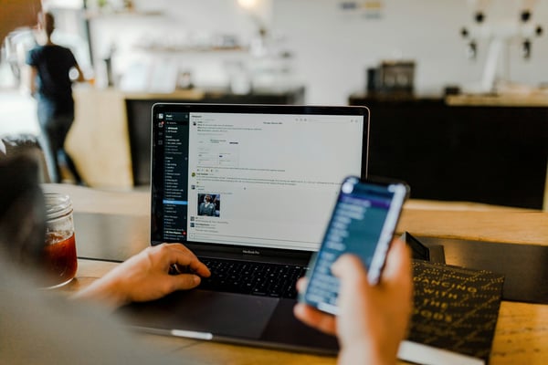 Slack message with team communicating and collaborating in app on desktop and mobile.Photo by Austin Distel on Unsplash